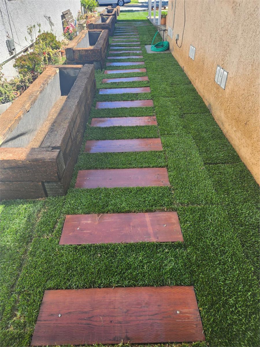 Garden walkway with wood stepping boards set into fresh turf
